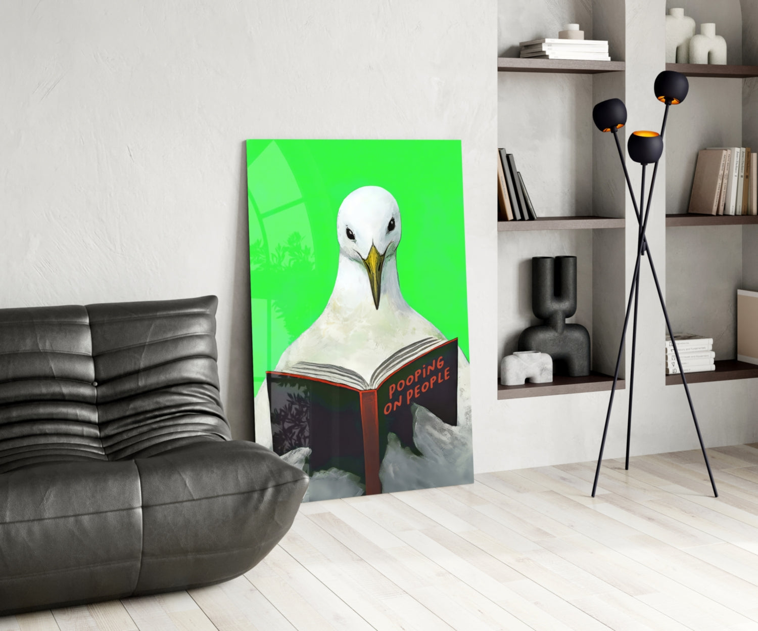 Bright green glass wall art depicting a white seagull reading a book titled "Pooping on People" displayed in a modern living room setting.