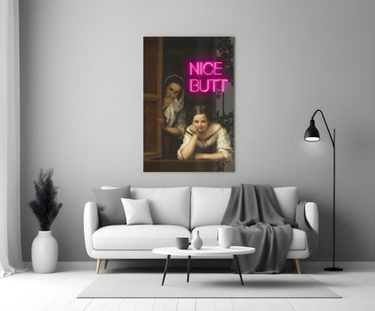 Classical painting of two women in a room with bright pink neon "NICE BUTT" text overlay, displayed above a white sofa in a modern living room.