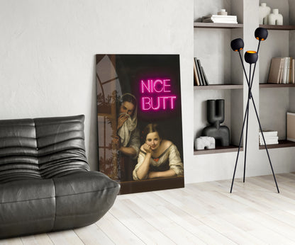 Modern living room interior featuring classic painting with bright pink "NICE BUTT" neon text overlay displayed on floor.