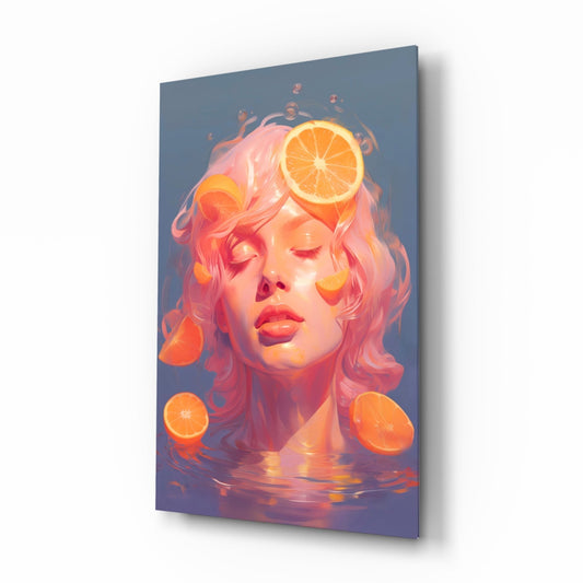 Glass wall art panel displayed at an angle showing a stylized female portrait with pink hair surrounded by orange citrus slices on a blue-purple gradient background.