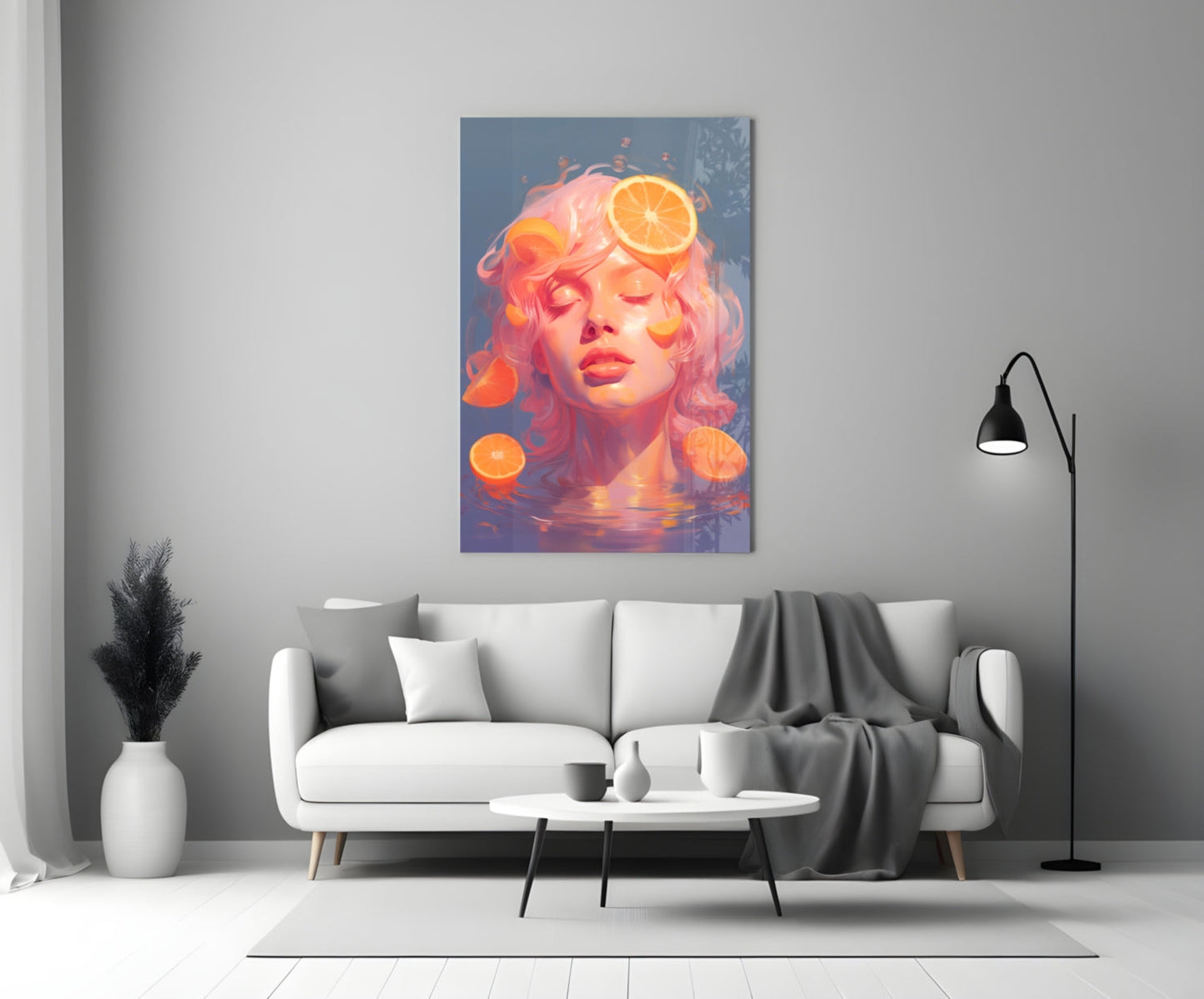 Glass wall art mounted above white sofa displays portrait of woman with pink hair and orange citrus slices against blue background.