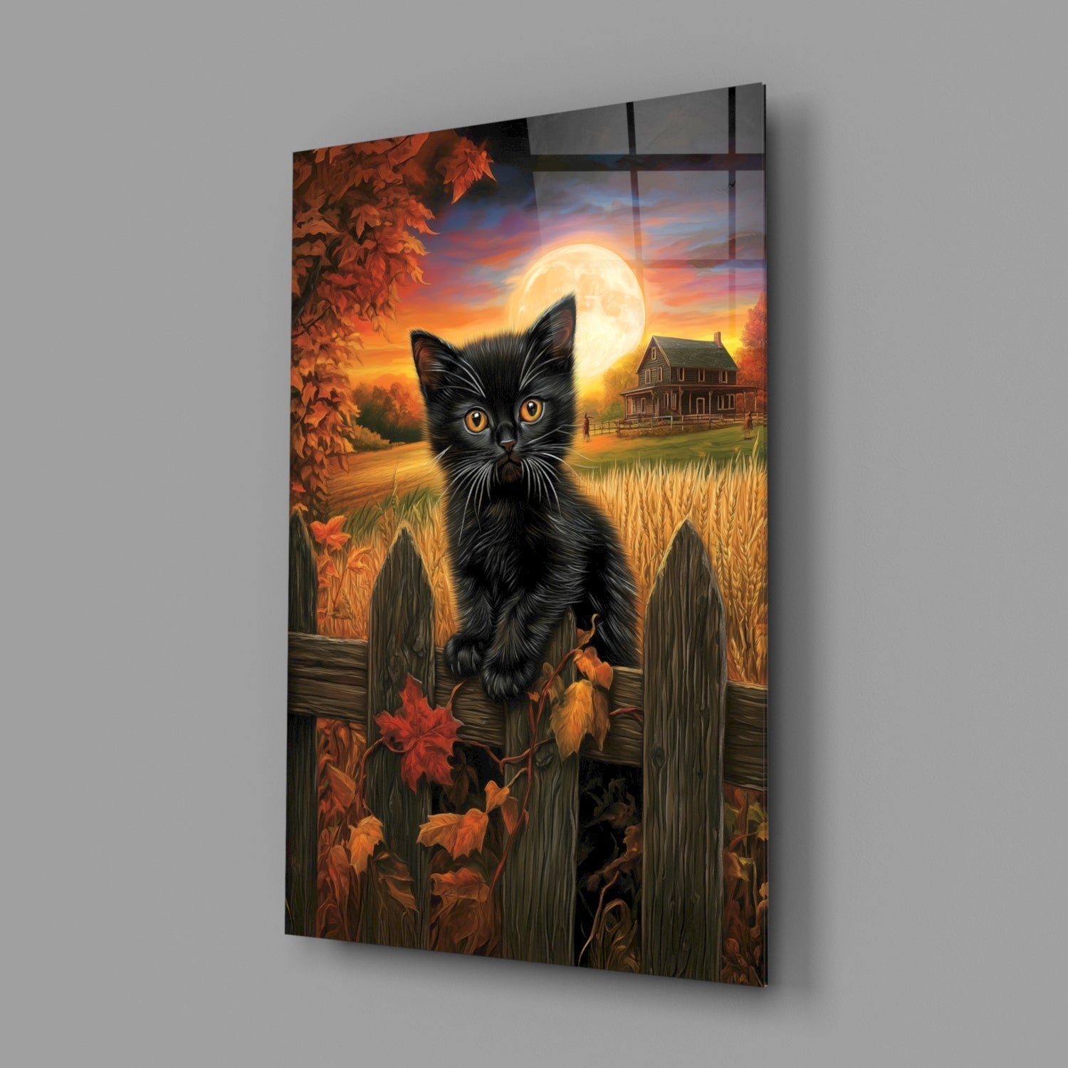 Black kitten with golden eyes perched on weathered fence, autumn landscape with full moon and farmhouse behind, mounted on gray wall.