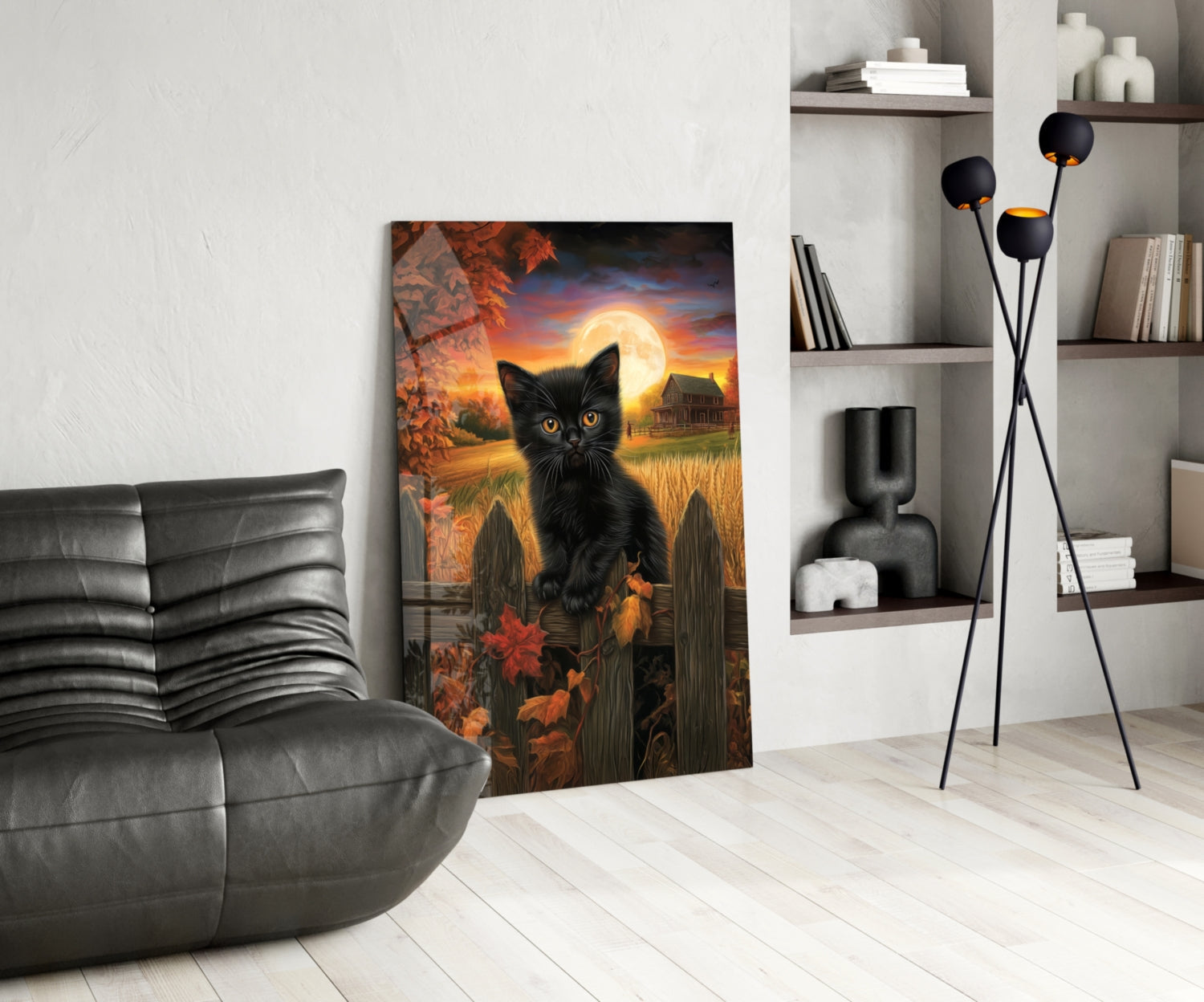 Autumn Cat glass wall art leaning against white wall in modern living room with gray sofa and shelving.