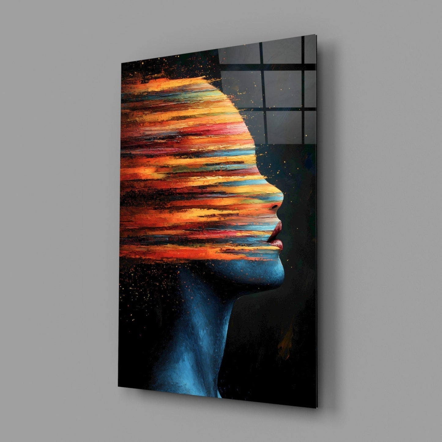 Profile view of glass wall art featuring a silhouetted face filled with a vibrant sunset landscape in orange, red, and blue tones.