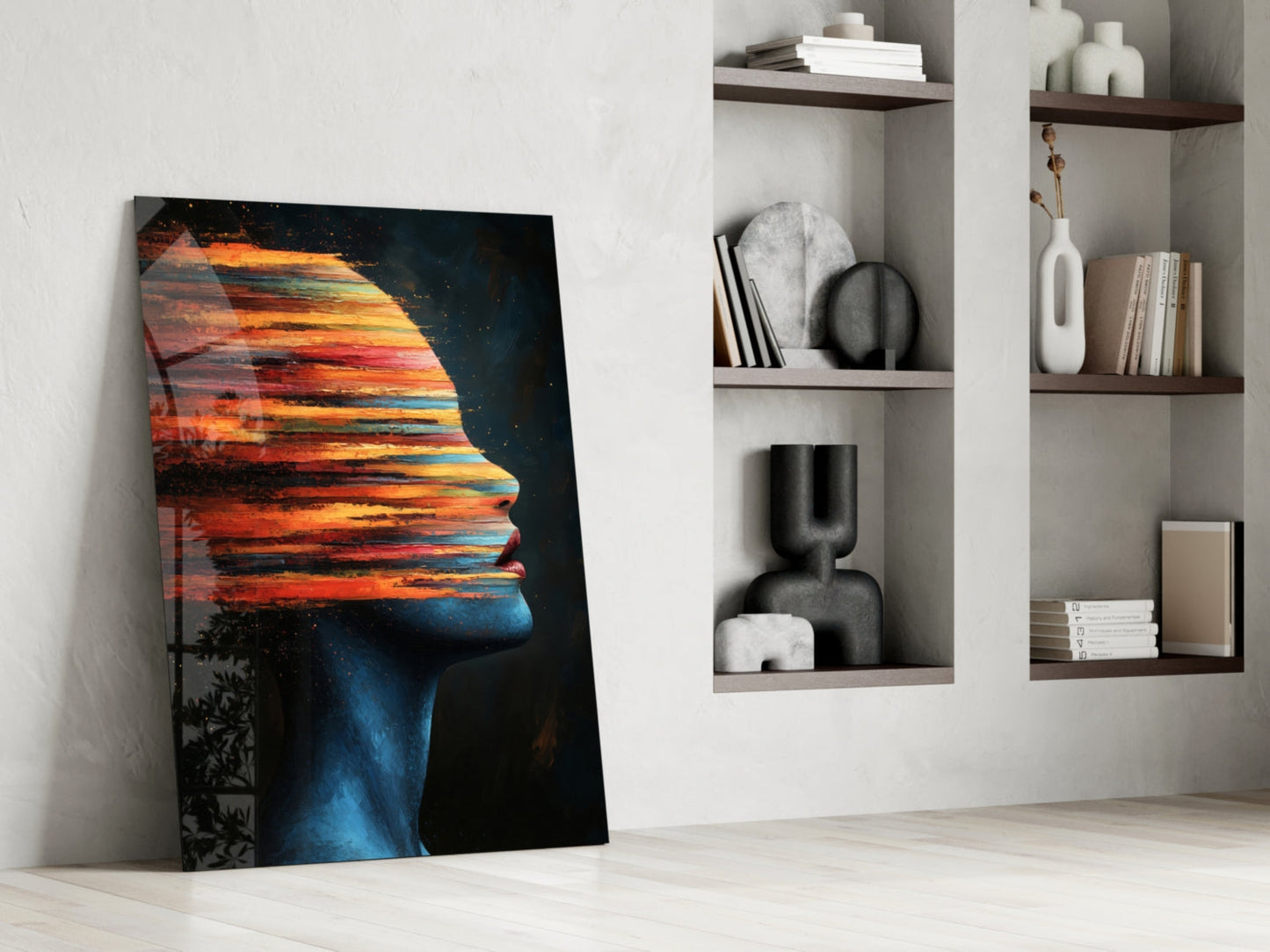 Colorful glass art leaning against white wall beside shelving unit displaying decorative objects and books.