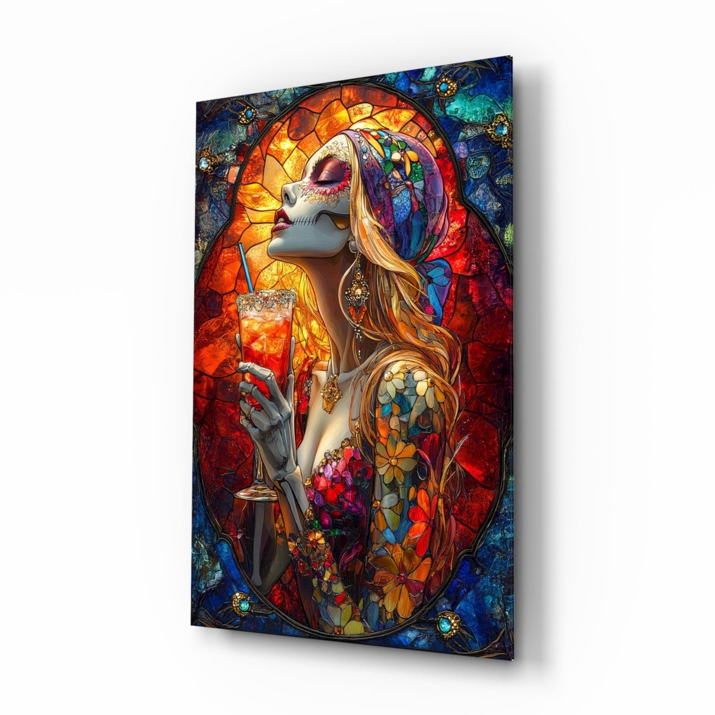 Glass wall art panel displayed at an angle showing a stained glass-style illustration of a skeletal figure with flowing hair holding a cocktail glass, featuring vibrant reds, blues, oranges, and gold tones.