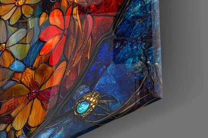 Close-up angled view of stained glass wall art featuring colorful flowers, a jeweled skull, and blue textured background sections with black leading.