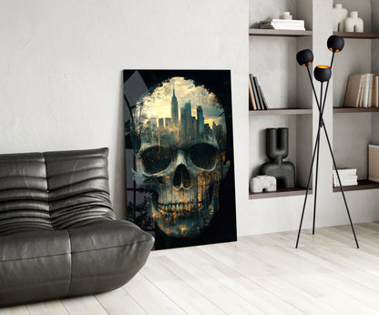 City skull glass wall art leaning against white wall in modern living room with grey sofa and shelving.