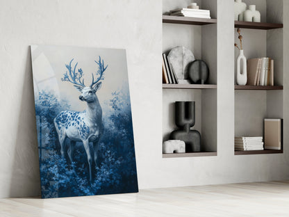 Blue deer glass wall art leaning against white wall next to built-in shelving with decorative objects and books.