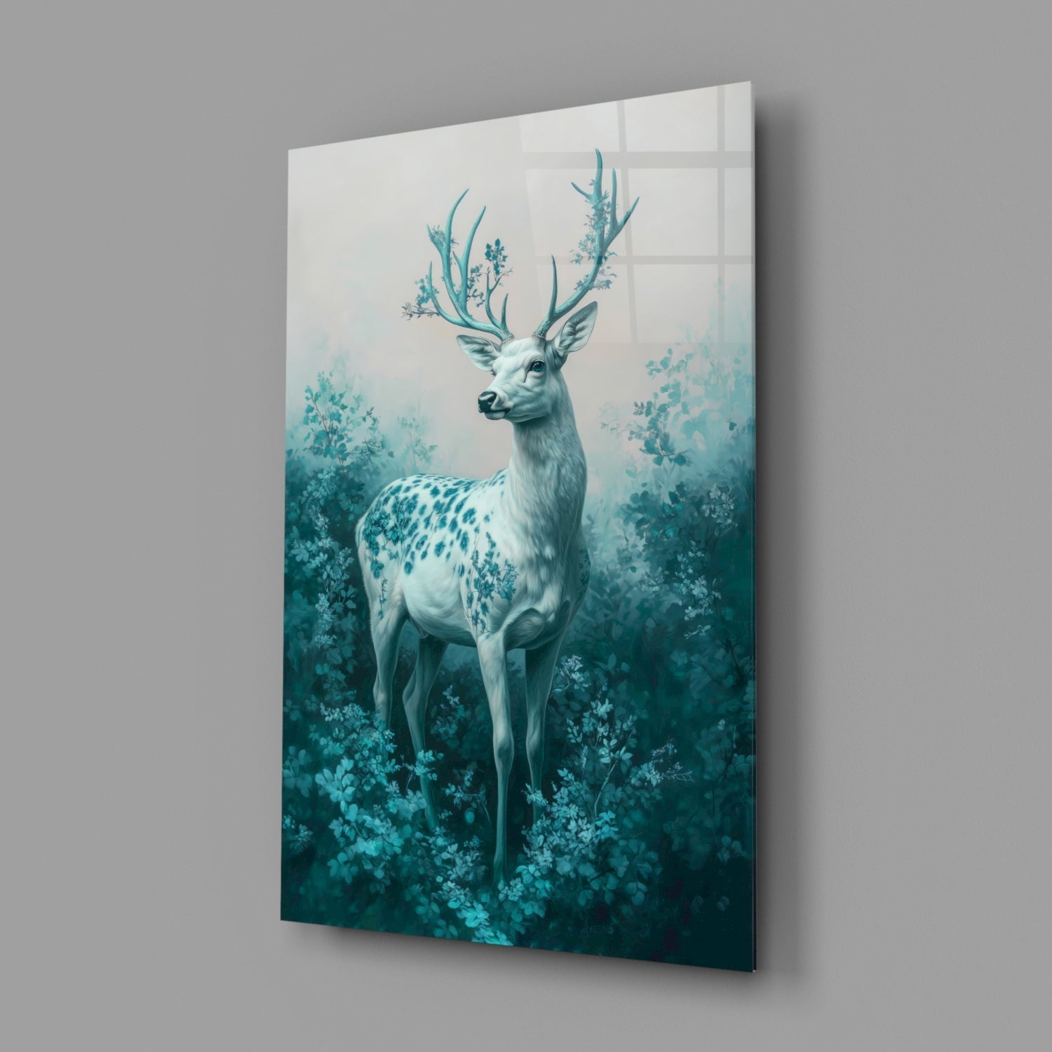 Angled view of glass wall art displaying a white deer with turquoise antlers surrounded by teal foliage against a gradient background.