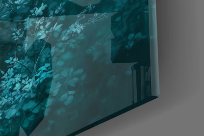 Angled view of frosted turquoise glass panel featuring etched botanical and deer silhouettes casting shadows on white wall.