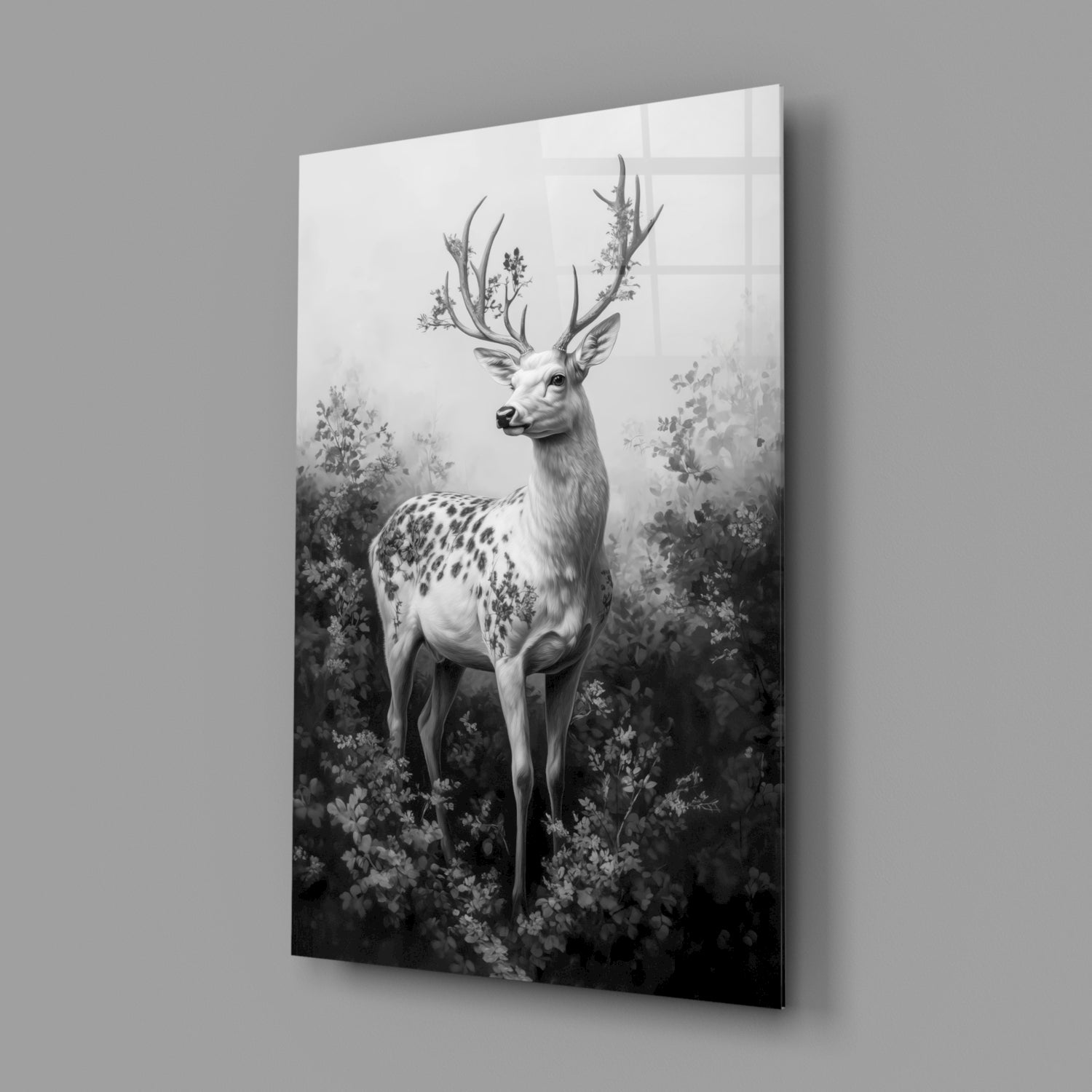 Angled view of a monochrome glass wall panel displaying a spotted deer with flowering antlers surrounded by botanical foliage.