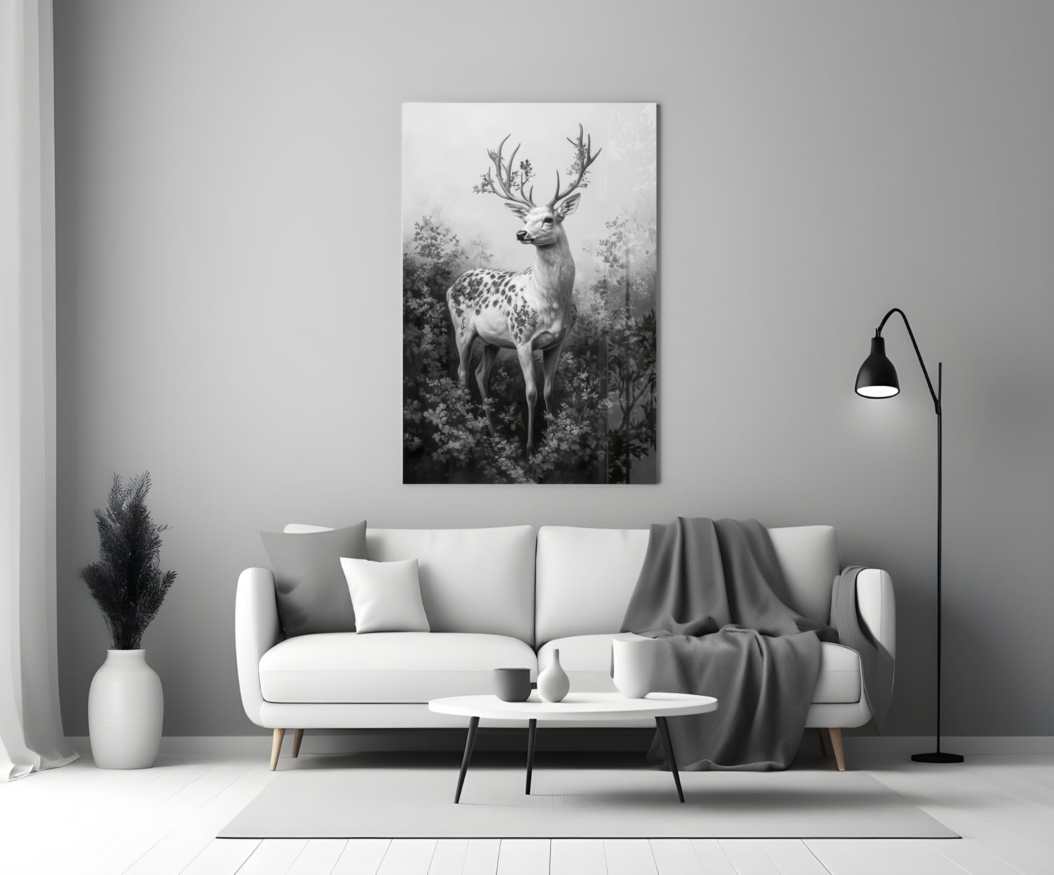 Monochrome glass wall art depicting a spotted deer with antler branches displayed above a white sofa in a minimalist interior.