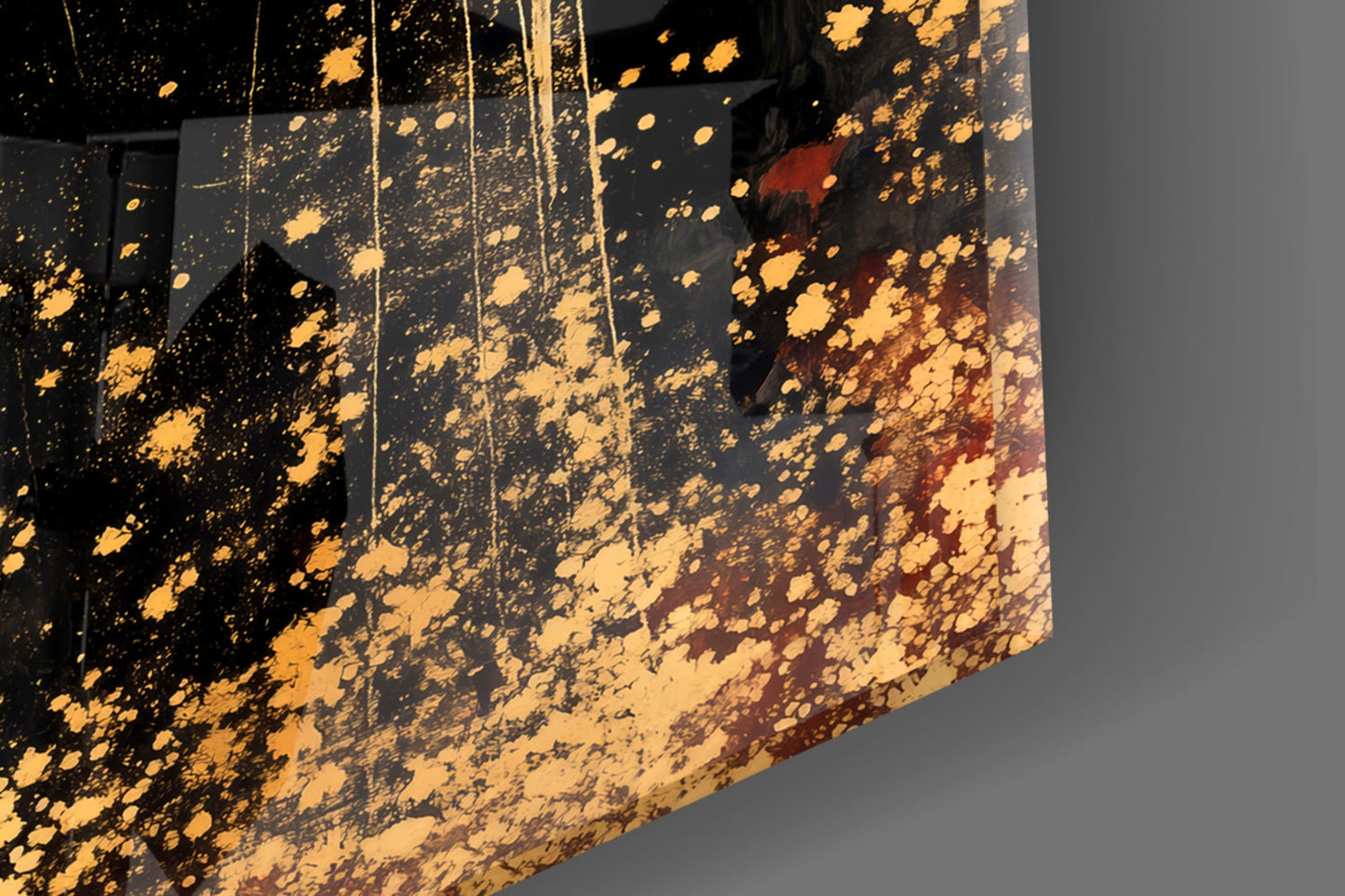 Close-up angled view of black glass panels with gold and burgundy splatter pattern and hanging strings.