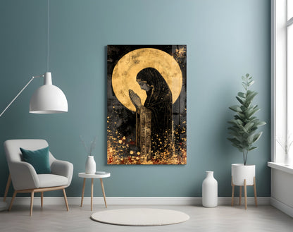 Golden glass wall art depicting a praying figure with halo in modern teal room setting with furniture.