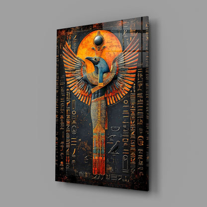 Angled perspective view of glass wall art featuring an Egyptian winged deity with orange and blue coloring against dark background with hieroglyphic text.