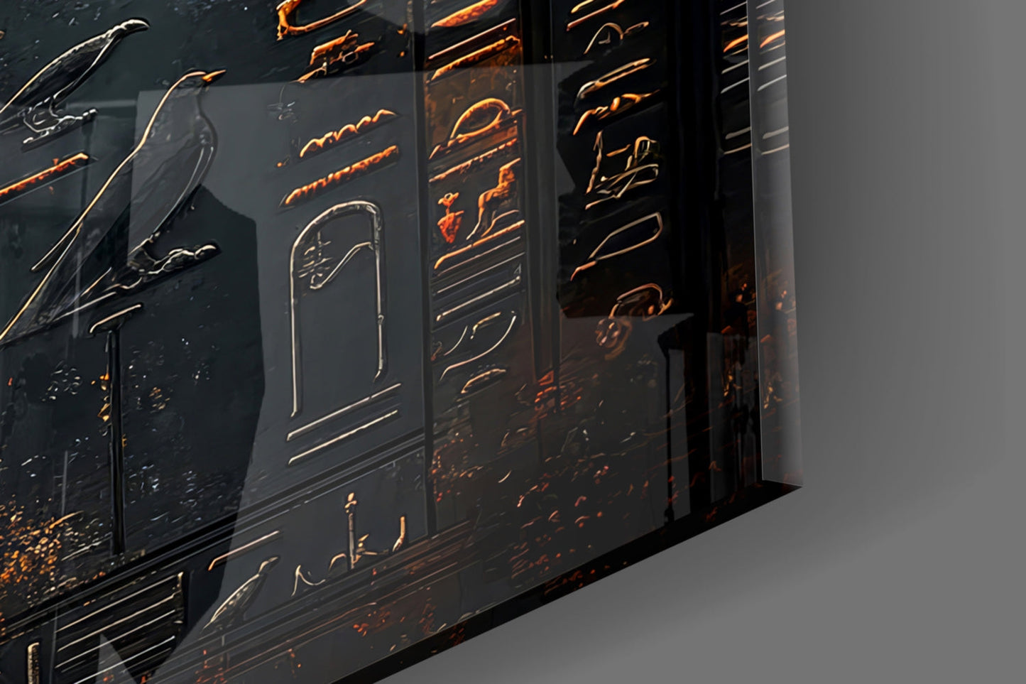 Close-up angled view of black glass panels with gold-etched winged figures and hieroglyphic designs, backlit to highlight relief details.