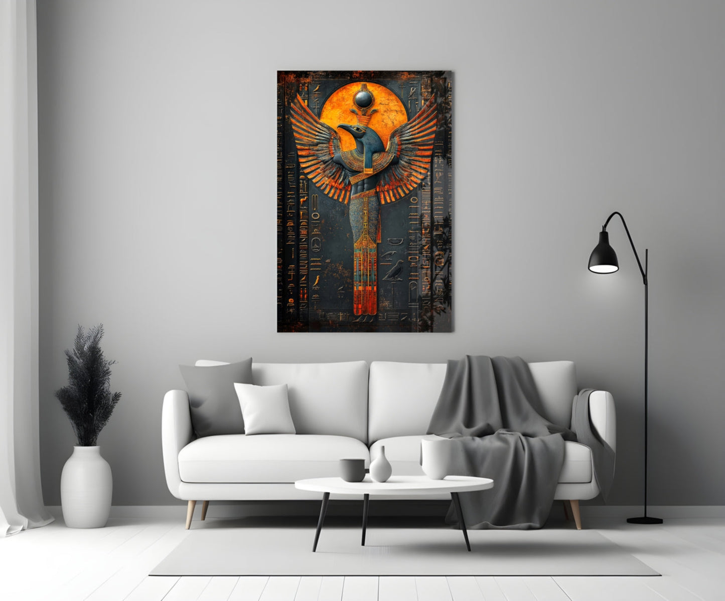 Egyptian-inspired winged deity glass art in orange and gold tones displayed above a white sofa in a modern living room.