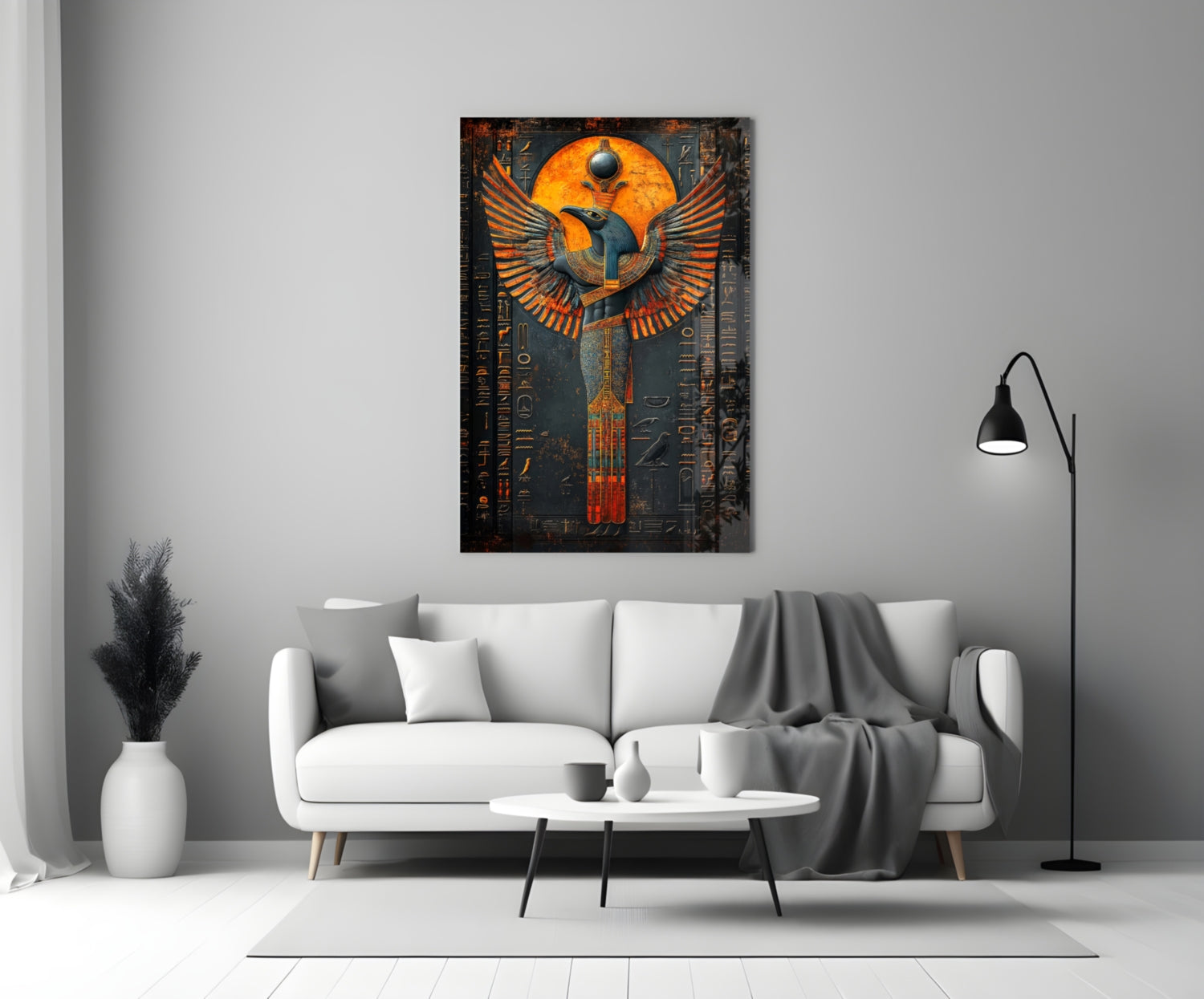 Egyptian-inspired winged deity glass art in orange and gold tones displayed above a white sofa in a modern living room.