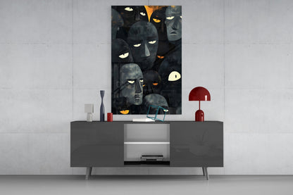 Dark glass wall art featuring stylized faces with glowing eyes displayed above a gray media console in a modern interior setting.