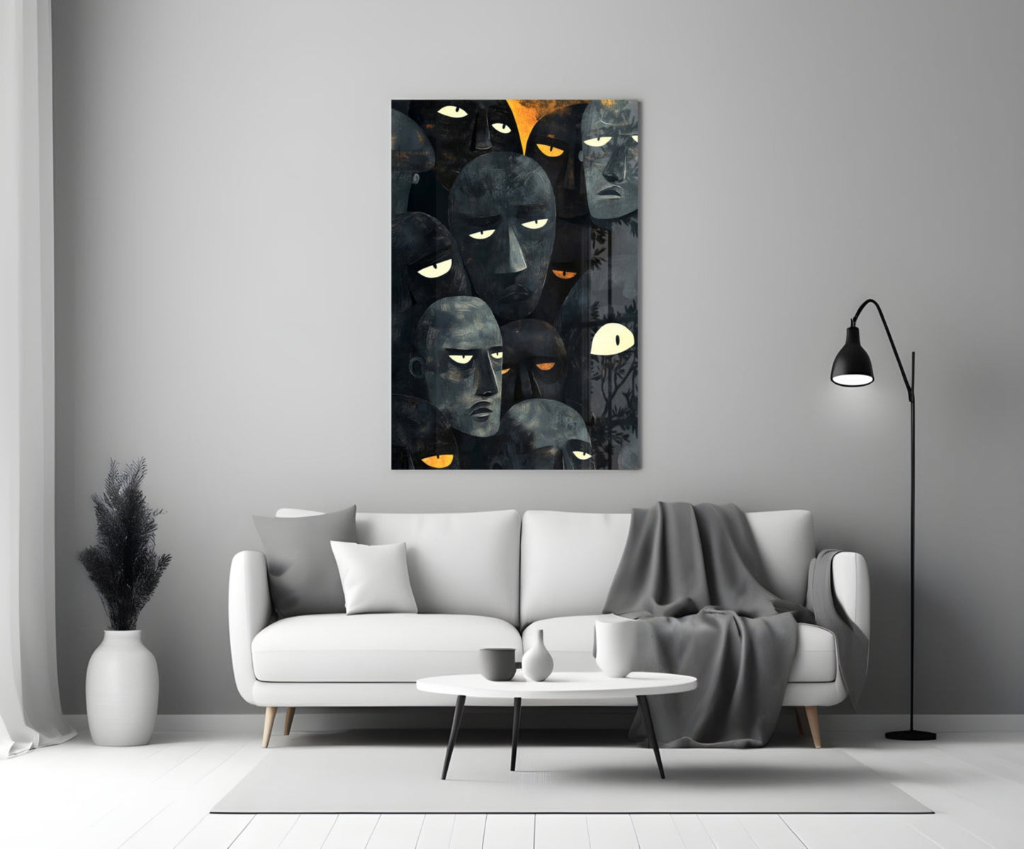 Dark glass wall art featuring multiple stylized faces with glowing yellow and orange eyes displayed above a white sofa in a modern living room.