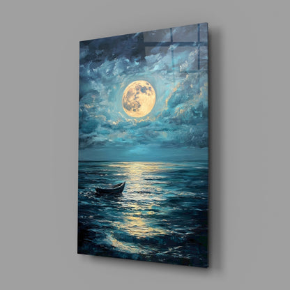 Glass wall art panel mounted on gray wall showing moonlit seascape with full moon, clouds, and small boat on water.