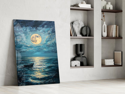 Glass wall art leaning against white wall displaying moonlit ocean scene with boat, beside built-in shelving with decorative objects and books.