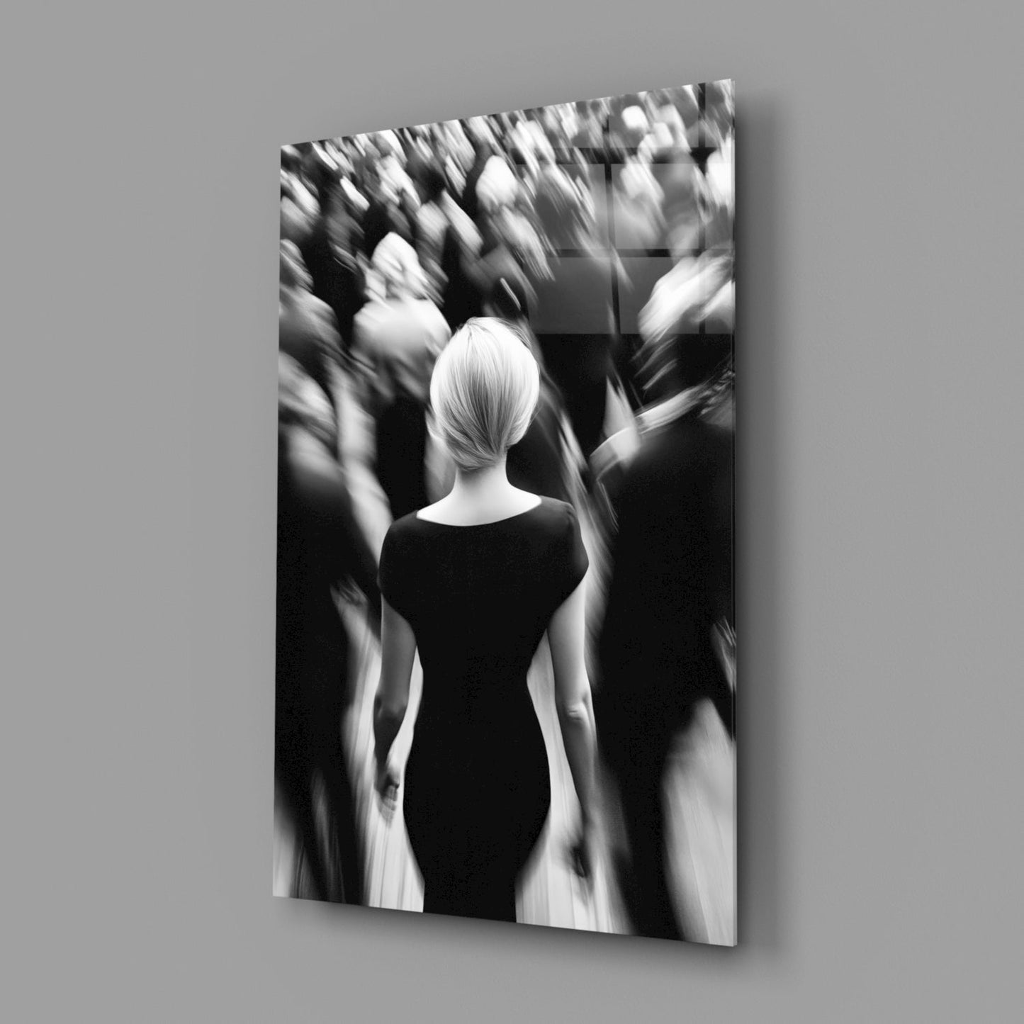 Black and white glass wall art depicting a solitary figure in dark clothing surrounded by blurred silhouettes in a crowded scene.