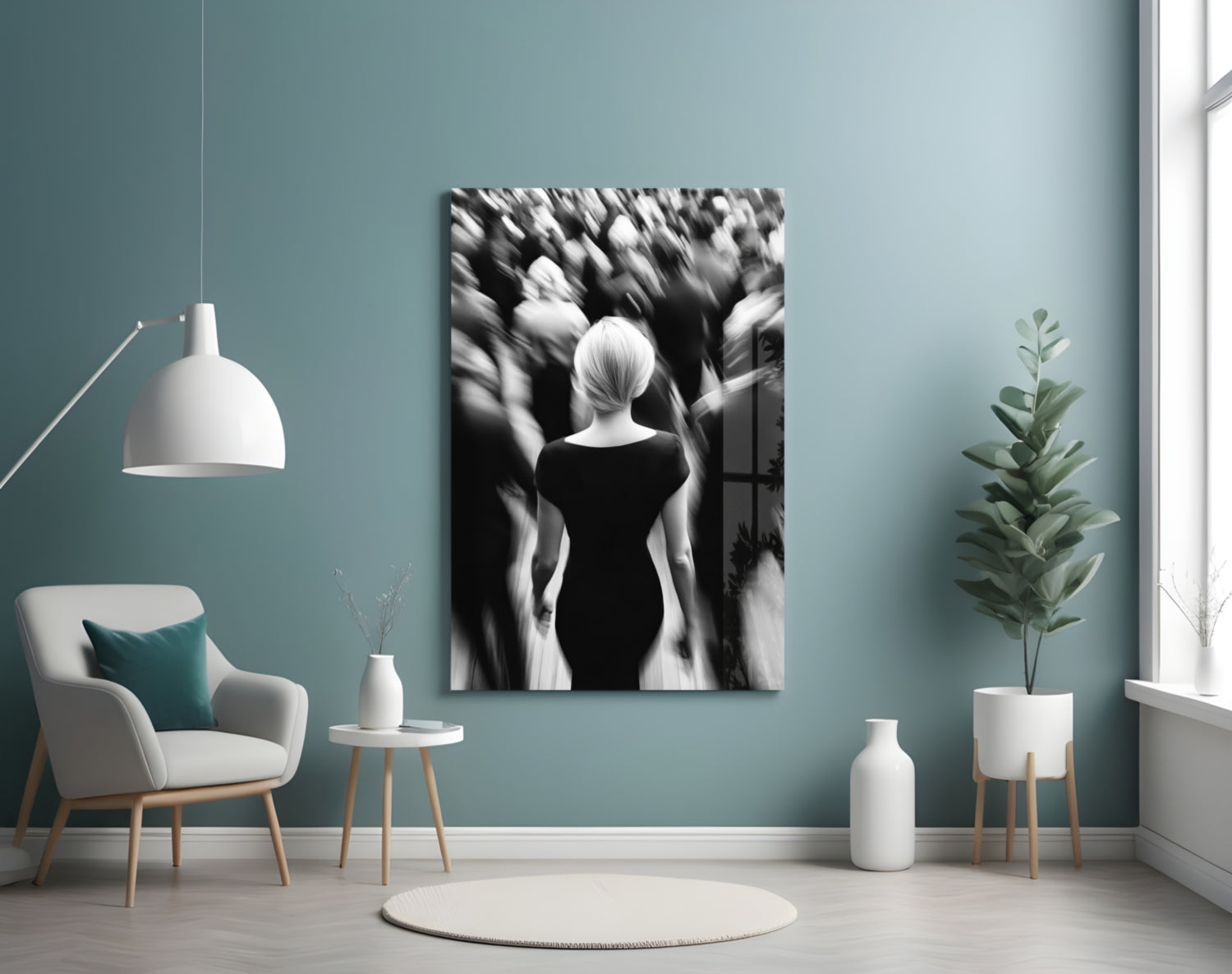 Black and white glass wall art depicting a solitary woman in dark dress surrounded by blurred figures, displayed in a minimalist room setting.