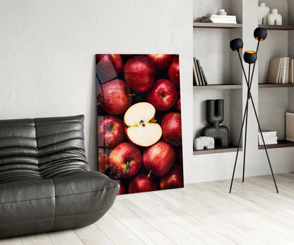 Modern living room with red apple glass wall art leaning against white wall beside gray sofa and black floor lamp.