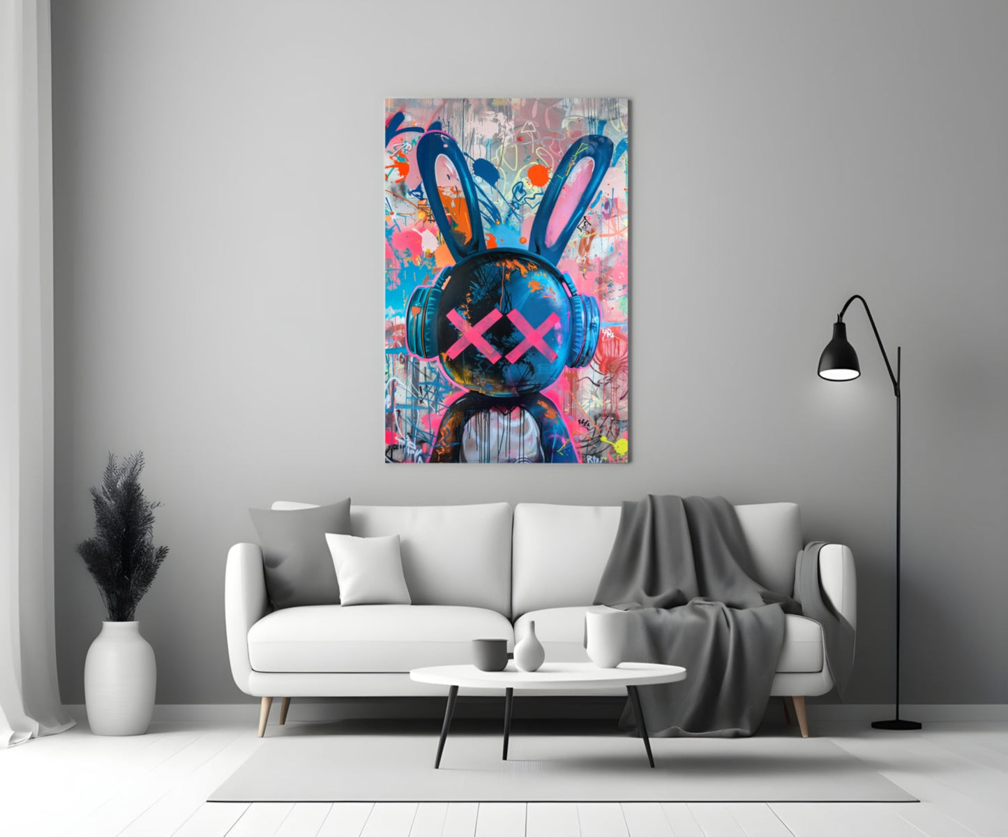 Colorful graffiti rabbit glass art with pink X eyes and headphones displayed above white sofa in modern living room.