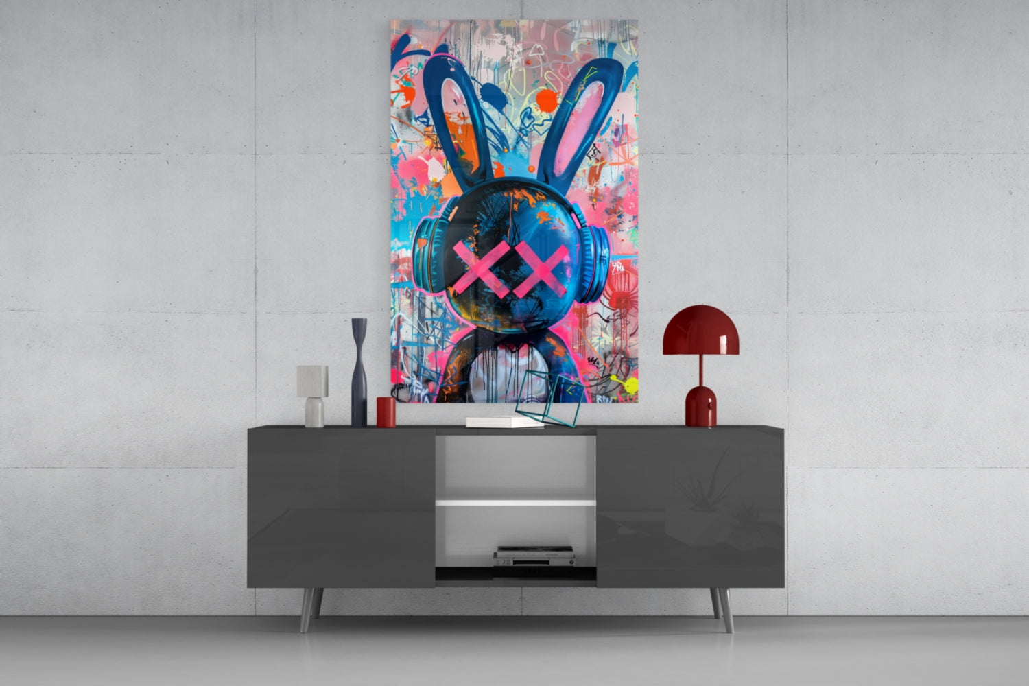Colorful graffiti rabbit glass wall art with pink X eyes and blue headphones displayed above gray media console in modern interior.