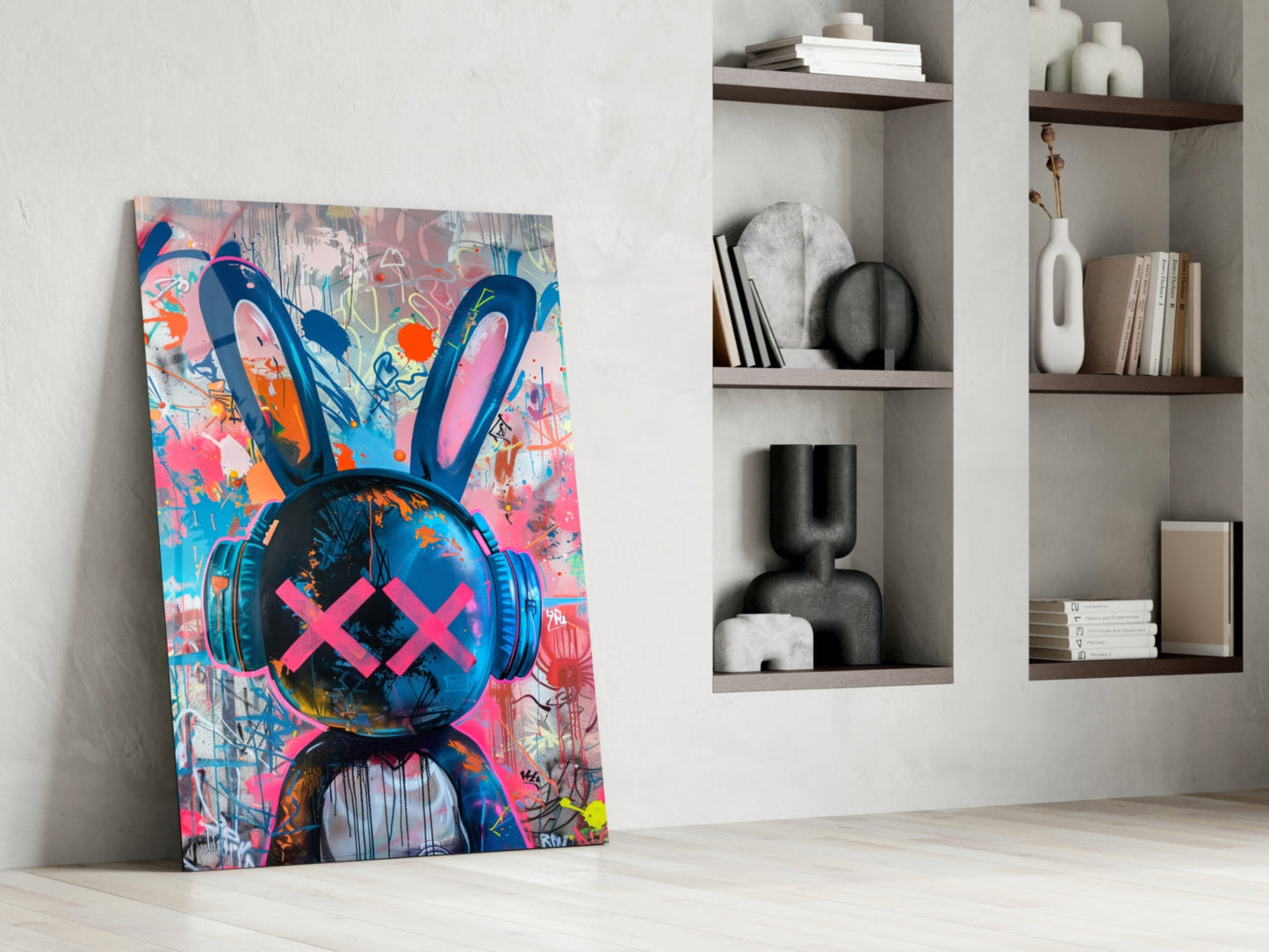 Colorful graffiti rabbit canvas leaning against white wall beside shelving unit displaying decorative objects.