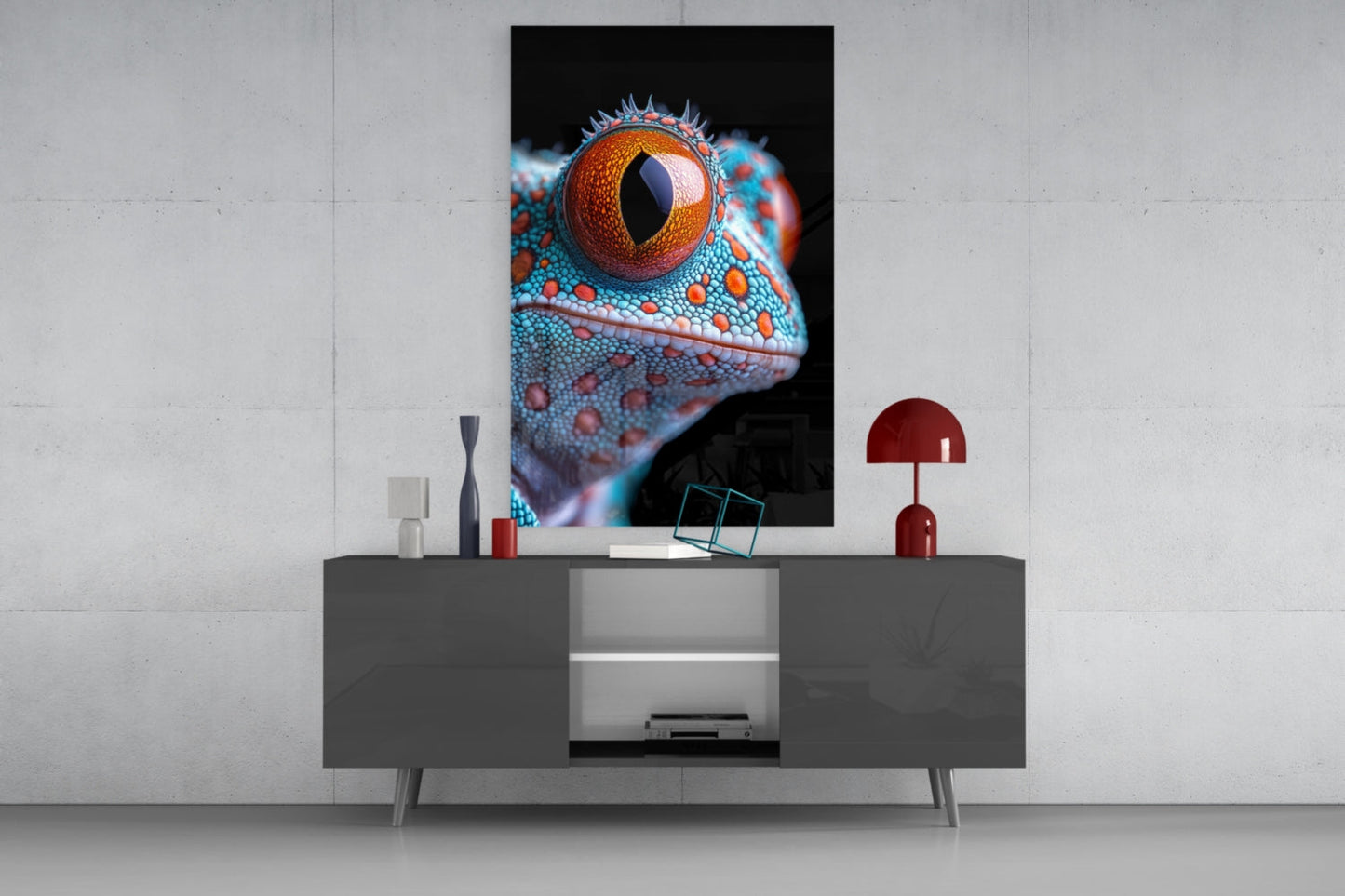 Vertical rectangular glass wall art depicting a close-up reptile eye in orange and turquoise, displayed above a gray media console with decorative accessories.