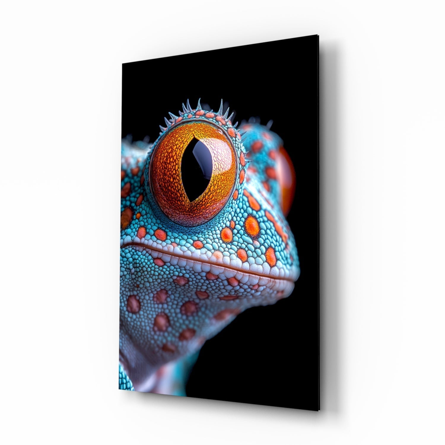 Close-up side profile of a colorful reptile eye with golden-orange iris and vertical pupil, turquoise and coral-spotted scaled head against black background on glass panel.