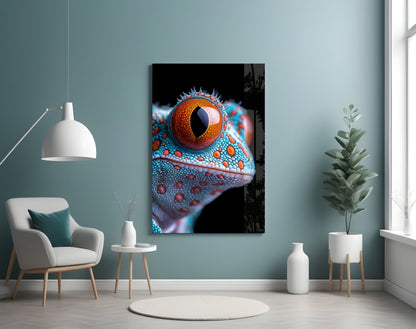 Framed glass wall art displaying a close-up of a reptile's eye with orange iris and blue textured scales against black background, mounted in modern living room.