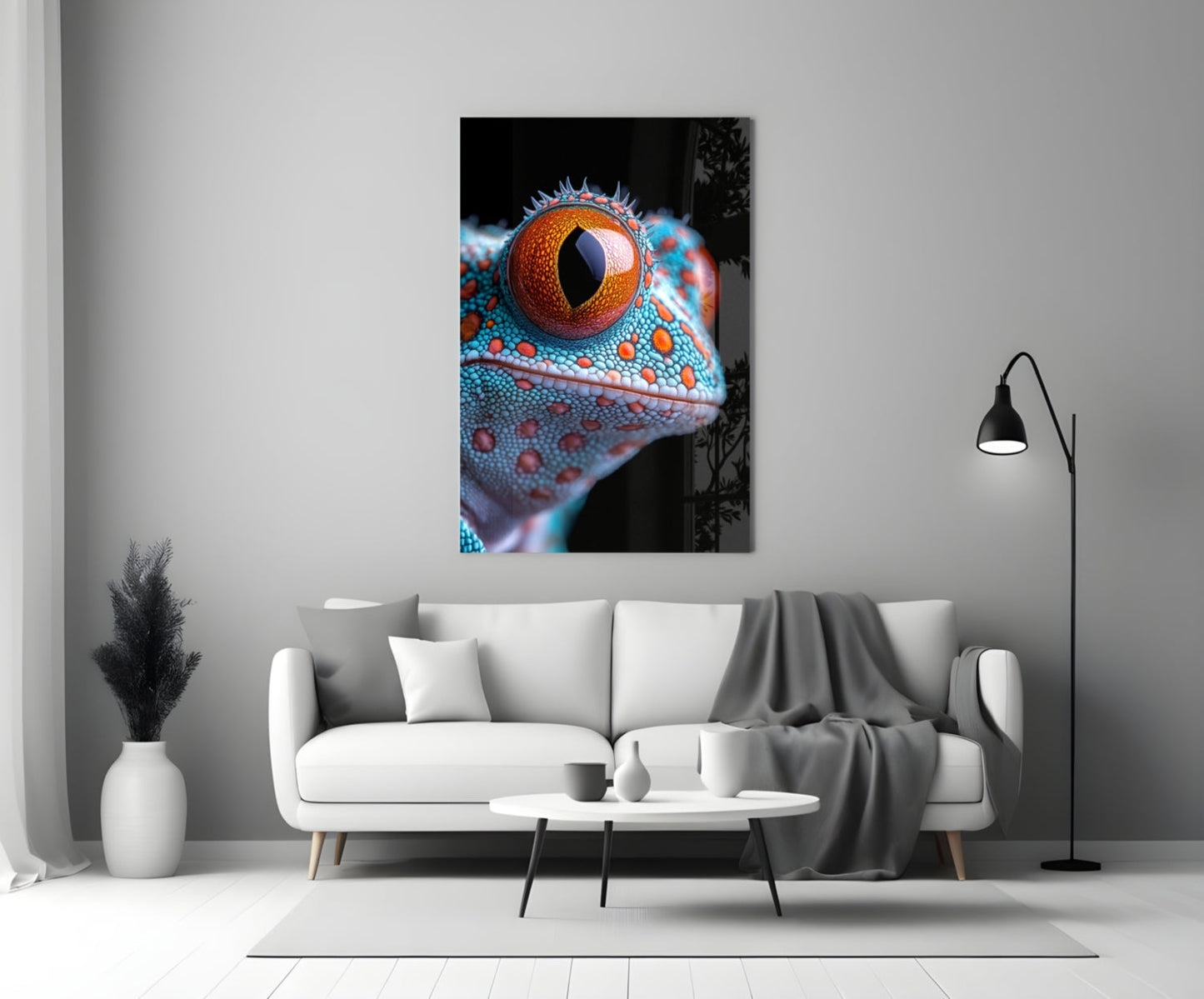 Framed glass wall art depicting a close-up of a reptile's head with vibrant turquoise scales and a striking orange eye displayed above a white sofa.