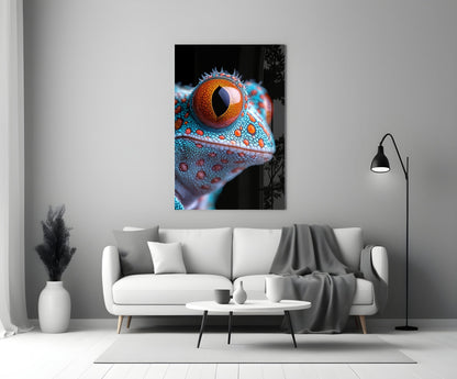Framed glass wall art depicting a close-up of a reptile's head with vibrant turquoise scales and a striking orange eye displayed above a white sofa.