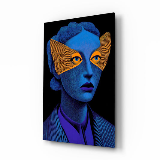 Angled view of glass wall art depicting a blue-skinned portrait with orange geometric eye mask and dark lips against black background.