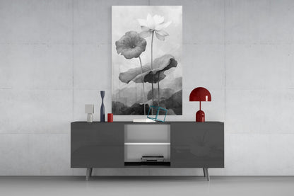 Black and white water lily glass wall art displayed above a dark gray sideboard with red decorative accents in a minimalist interior.