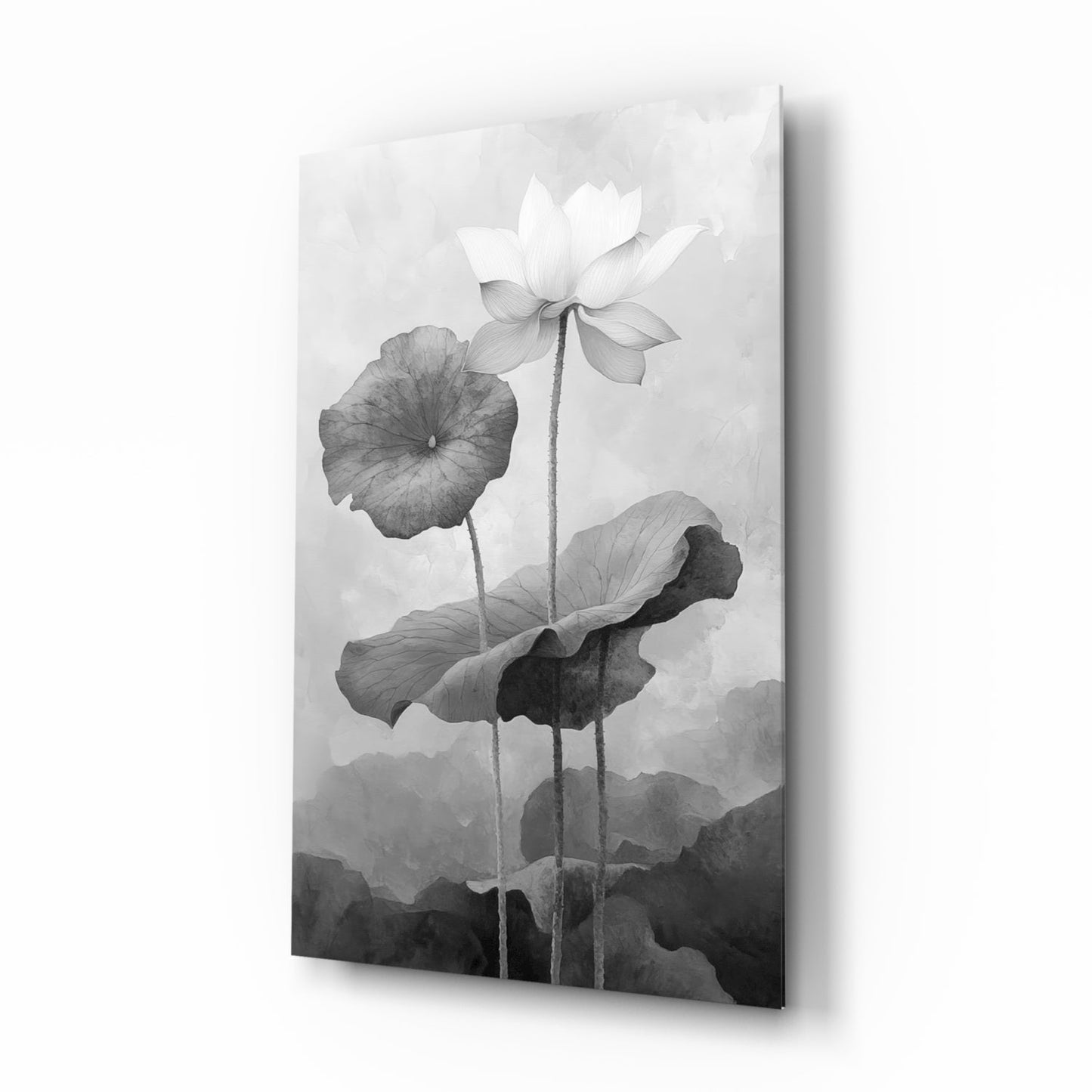 Black and white glass wall art displaying three water lilies with leaves against a misty mountain background, angled product shot.