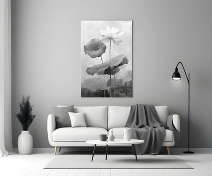 Black and white glass wall art depicting water lilies displayed above a white sofa in a minimalist living room setting.