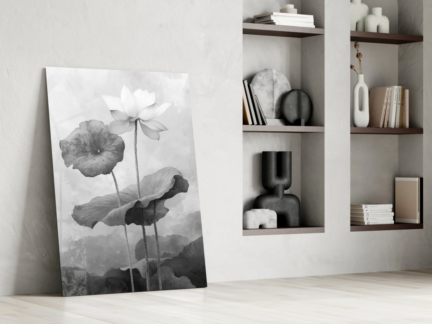 Black and white water lily canvas leaning against white wall beside built-in shelving with books and decorative objects.