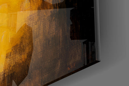 Close-up angled view of glass wall art showing golden-brown textured surface with dark silhouette details against white wall.