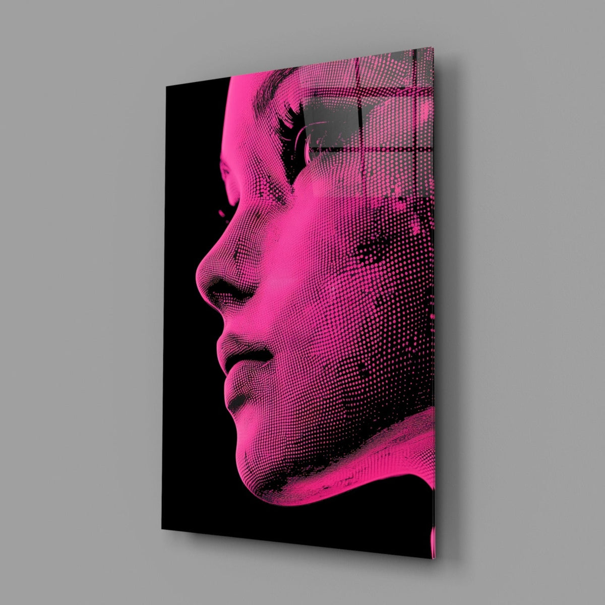 Angled perspective view of pink and black halftone portrait glass wall art displaying a woman's profile against gray background.