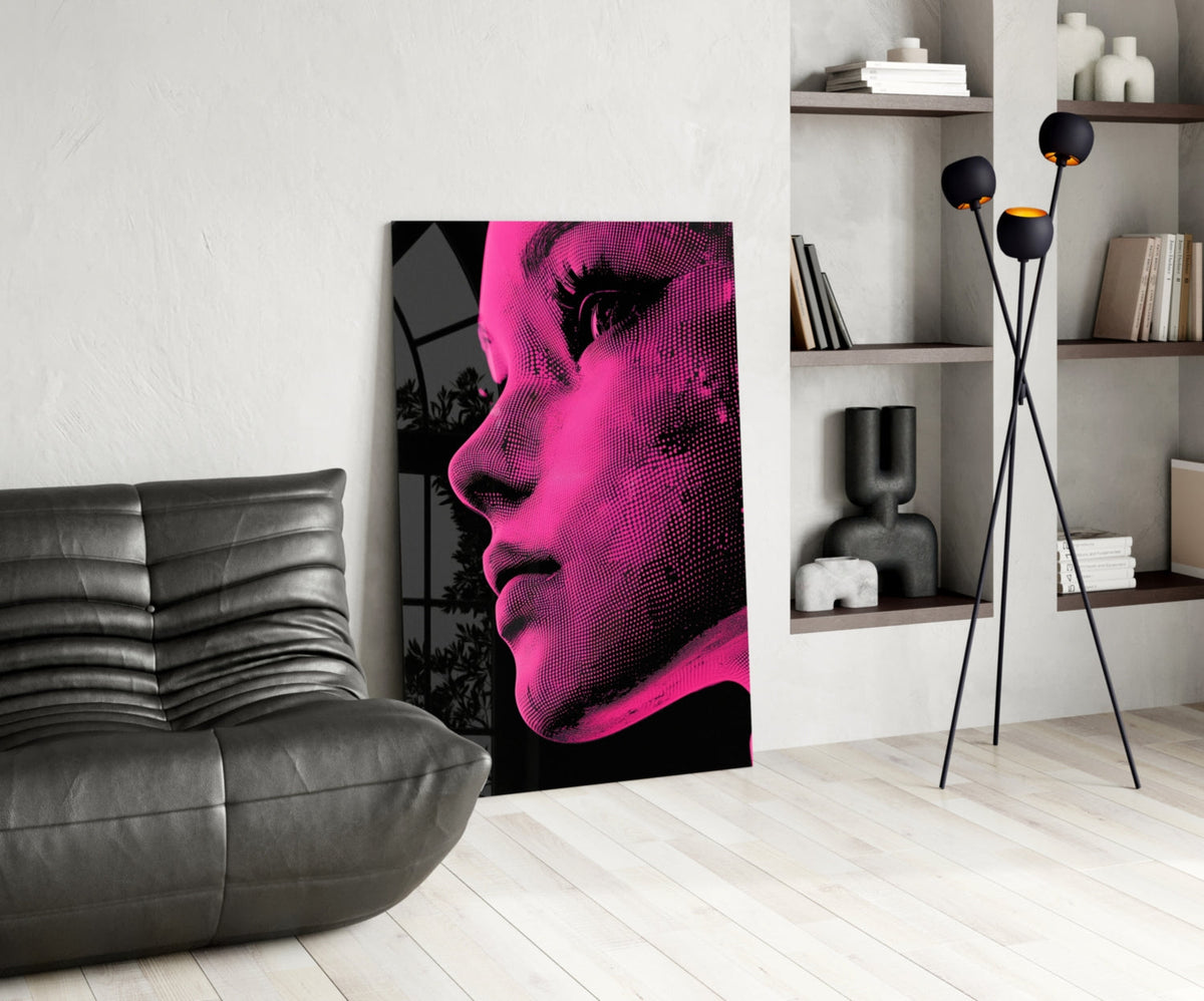 Modern living room interior featuring pink and black halftone portrait art leaning against white wall beside gray leather sofa.