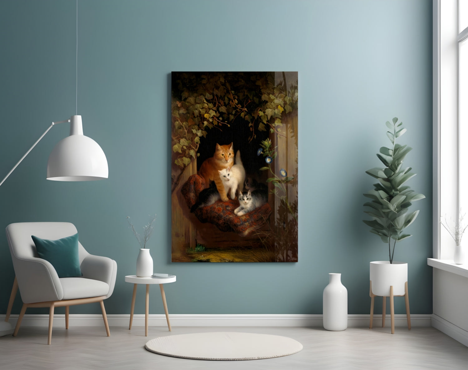 Canvas wall art depicting an orange and white cat with two kittens in a dark, floral-framed window setting, displayed in a minimalist room with teal walls.