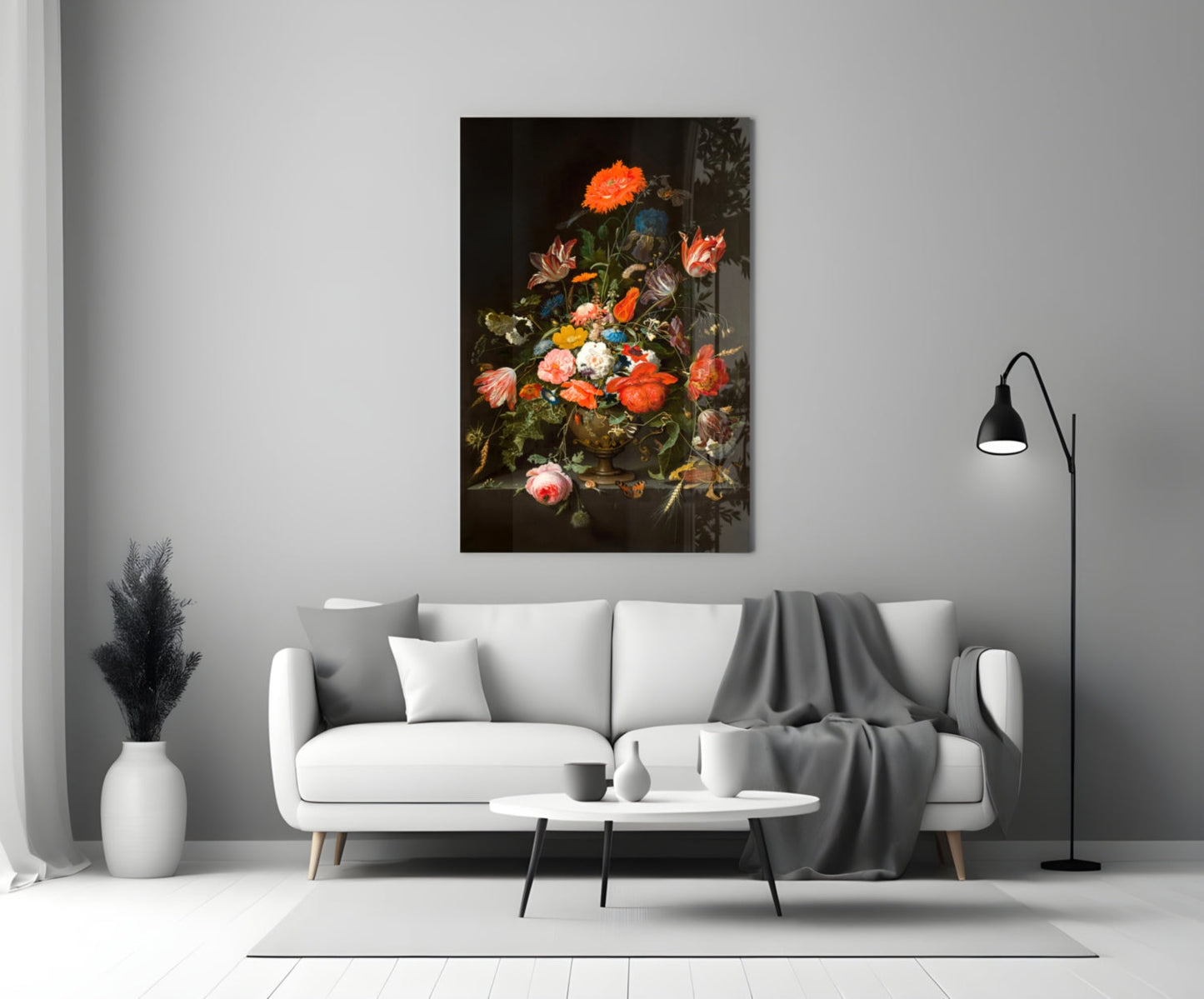Classic floral still life painting with vibrant orange, red, and pink flowers in a dark vase displayed above a white sofa in a modern living room.