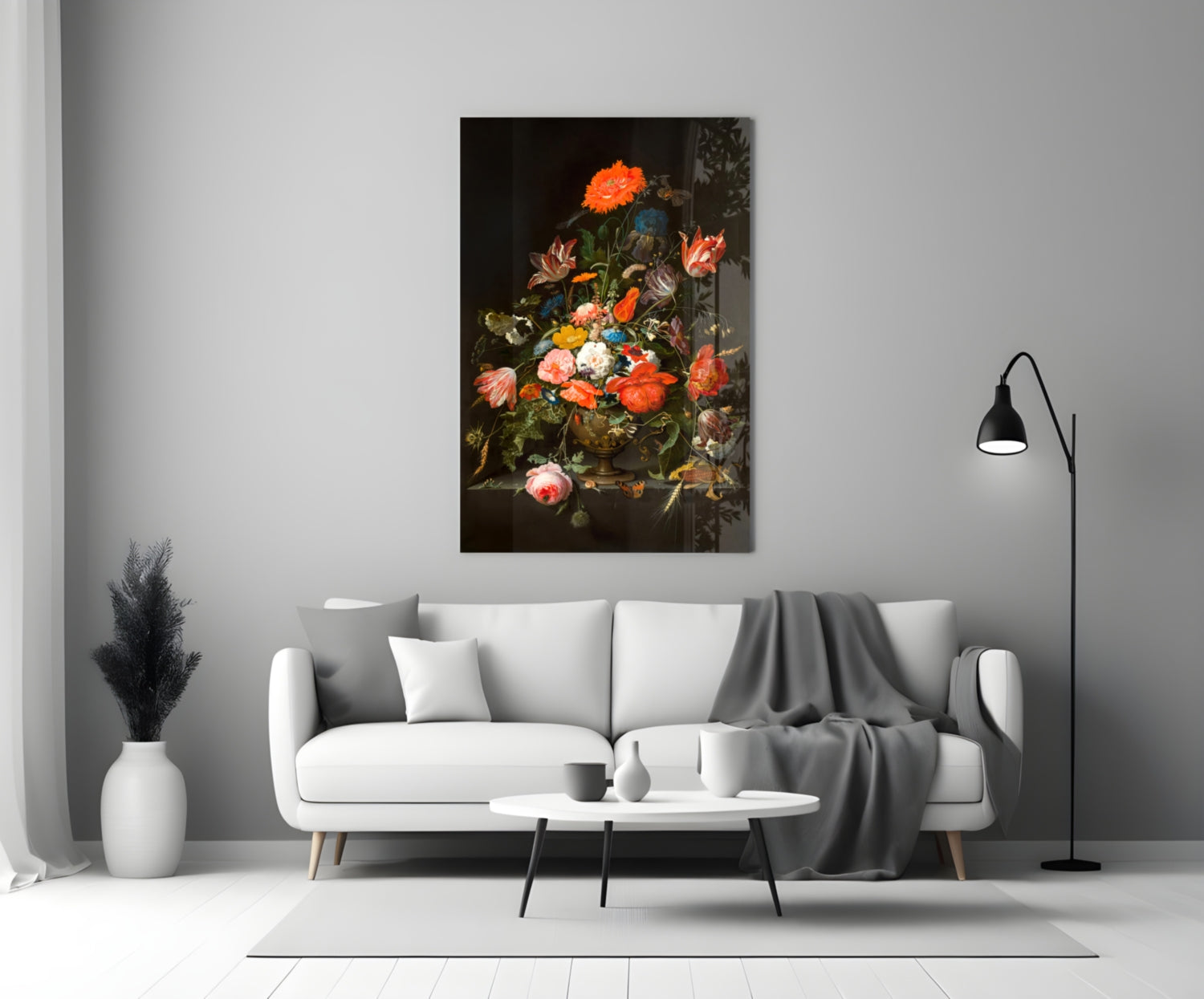 Classic floral still life painting with vibrant orange, red, and pink flowers in a dark vase displayed above a white sofa in a modern living room.