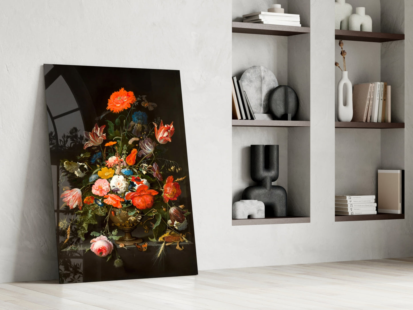 Glass art print of vibrant flowers in a vase displayed leaning against a white wall beside open shelving with decorative objects.